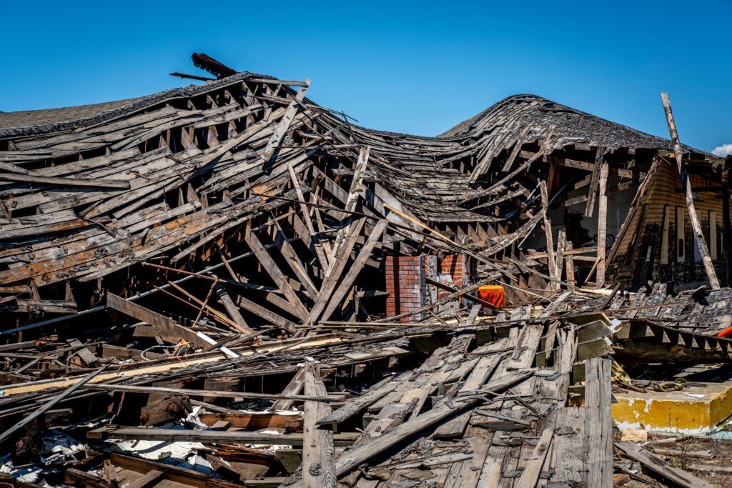AAR Turkiye and Syria A dramatic view of a destroyed wooden building after a catastrophe, showing debris and structural failure.